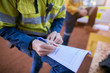 © Kings Access - Rope access miner supervisor written checking reviewing inspecting issuer the paper work permit prior to work on construction mine site Perth, Australia