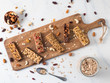 Granola bar with copy space. Set of different granola bars on cutting board over white marble table. Shallow DOF. Top view or flat lay.