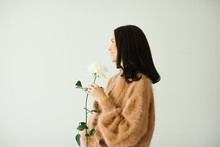 Smiling Pretty Woman Wearing Cashmere Beige Sweater Holding A White Rose