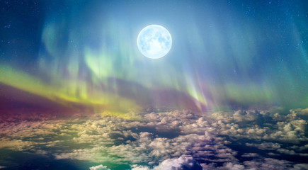 northern lights (aurora borealis) in the sky over clouds with full moon 