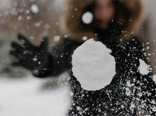 The Girl Throws A Snowball At The Camera. The Snowball Shatters Into Snowflakes