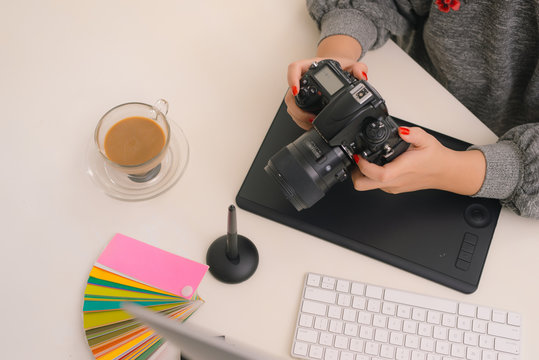 Young asian female designer using graphics tablet while working with computer at studio or office.