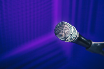 Wall Mural - microphone on stand, purple background with acoustic foam wall in studio