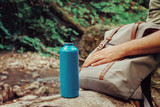 Fototapeta Koty - Hiker man sitting with backpack and bottle of water on nature.