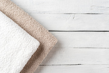 Clean folded towels on white wooden table with copyspace. Top view