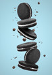 Falling chocolate cookies on color background