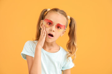 surprised little girl on color background