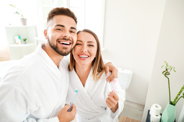 Wall Mural - Young couple brushing teeth in bathroom