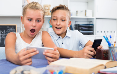 Wall Mural - Boy is watching a video with a girl in her smartphone