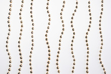 Gold Beads Isolated On White Background. Background Made Of A Brilliant Celebratory Beads Of Golden Color.