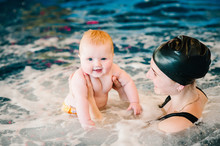 Whirlpool, Jacuzzi. Diving Baby In The Paddling Pool. Young Mother, Swimming Instructor And Happy Little Girl In Pool. Learn Infant Child To Swim. Enjoy The First Day Of Swimming In Water.