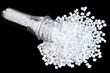 Polypropylene (PP) granules with blow injection molding bottle preform isolated on black background, selective focus.