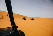 Off Road Buggies Crossing Dunes In The Desert. Rally Raid Adventure.