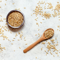 Brown rice in a wooden bowl with a  spoon