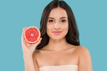 Wall Mural - happy woman holding half of grapefruit isolated on blue