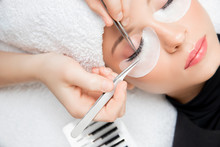Eyelash Extension Procedure. Master Tweezers Fake Long Lashes Beautiful Female Eyes