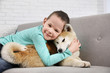 © New Africa - Happy boy with Akita Inu dog on sofa. Little friends
