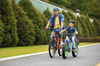 © New Africa - Dad and son riding modern bicycles outdoors