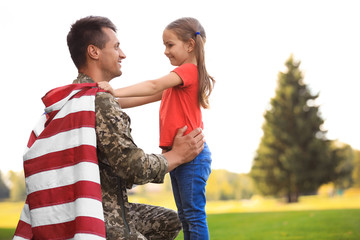 Wall Mural - Father in military uniform with American flag and his daughter at sunny park