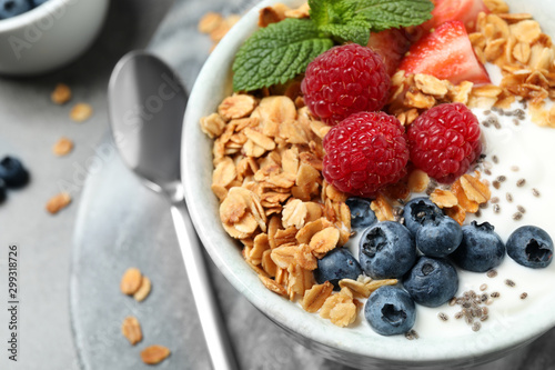 Fotografía Tasty homemade granola with yogurt and berries on grey table, closeup