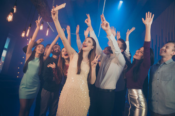 Wall Mural - Good mood best meeting concert city life concept. Photo of nice glad positive raising hands up buddies taking selfie on cell in luxurious neon place saying hello to blogger subscribers