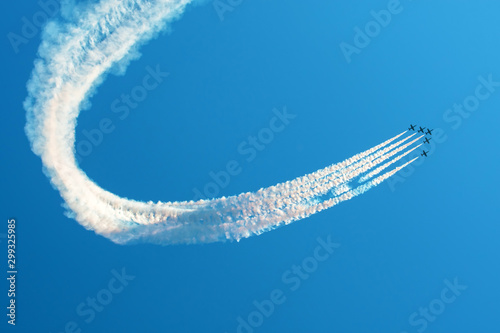 Tela Fighter jets flying against a bright sky, performing figures turns from the smoke