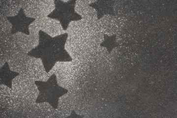 Stars figure made of sugar powder on dark gray background