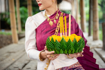 Beautiful woman ware Traditional Thai dresses hold floating basket or kratong, loy kratong festival in Thailand