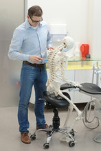 Expert Pointing At Thoracic Spine Of Human Skeleton Model As A Dentist In Sitting,leaning Position At Work - Occupational Disease Concept
