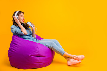 Sticker - Profile side view of her she nice attractive cheerful cheery wavy-haired girl sitting on bag chair listening music singing song weekend isolated on bright vivid shine vibrant yellow color background