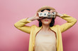 © LIGHTFIELD STUDIOS - asian woman holding wooden cubes in front of face with fake and fact lettering isolated on pink