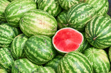 A total plan of a pile of watermelons on which lies the cut half of the watermelon. Half of the watermelon pitted ready for sale. Trade watermelons outdoors.
