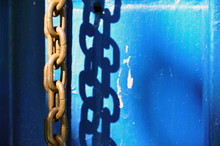 Rusty Metal Chain Creates A Bold Shadow In Bright Sunlight.