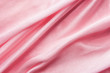 Delicate pink jersey fabric background with swirl creased texture. Sewing fashion clothes making wedding women's apparel concept