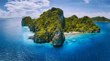 Aerial Drone Panorama View Of Tropical Paradise Island. Karst Limestone Rocky Mountains Surrounds By Blue Ocean And Coral Reef