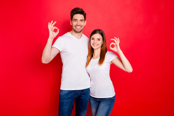 Poster - Photo of cheerful positive nice cute charming couple boyfriend girlfriend showing ok sign in jeans denim white t-shirt smiling toothily hugging isolated vivid color background