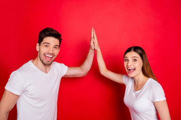 Poster - Photo of cheerful positive students redhair nice pretty couple of spouses smiling toothily celebrating victory clapping hands high five isolated in white t-shirt vibrant color red background