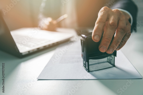 Fotografía businessman put a stamp on business contract in office