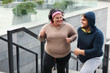 © New Africa - Overweight couple running up stairs together outdoors