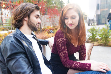 Man and woman together outside on park bench on a sunny day