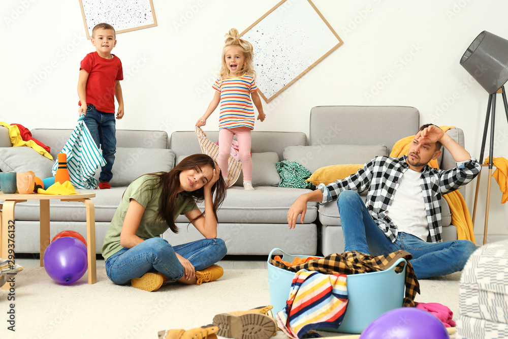 Frustrated parents and their mischievous children in messy room - obrazy, fototapety, plakaty 