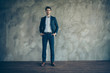 © deagreez - Full length body size photo of handsome attractive confident man wearing trousers with hands in pockets with stubble in shoes isolated grey color background