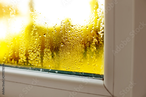 Window drip due to bad ventilation inside house. Condensation on glass during cold weather. High humidity is cause of mold (mildew, mould) on house or building surfaces. Water drop tracks on windows.