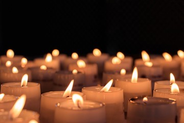 Sticker - Closeup shot of lighted candles for a religious ceremony in a dark area