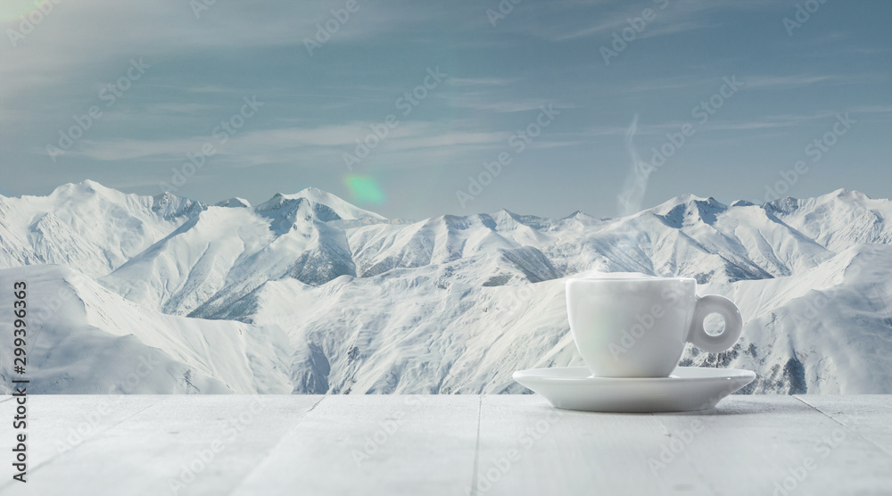 Single tea or coffee cup and landscape of mountains on background. Cup of hot drink with snowly look and cloudly sky in front of it. Warm in winter day, holidays, travel, New Year and Christmas time. - obrazy, fototapety, plakaty 