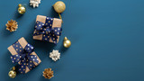 Fototapeta Mapy - Christmas blue background with a border of gift boxes, golden balls and decorations. Flat lay, top view, copy space. Xmas banner mockup, vintage postcard template
