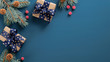 Christmas tree branch with red berries and gift box over blue xmas background. Flat lay, top view, copy space. Christmas banner mockup with copy space