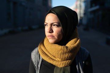 Portrait of a young woman wearing headscarf looking toward sunshine