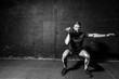 © Srdjan - Young strong fit muscular sweaty man with big muscles strength cross workout training with dumbbells weights in the gym dark image with shadows real people black and white