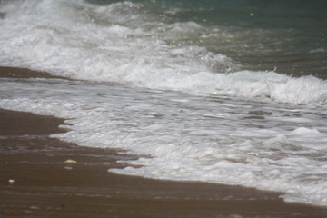 Aegean sea: sand, water, ripples, reflections, waves and lighthouses